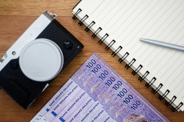 Malezya para birimi Malezya ringgit banknotları, kamera ve not edilmiş arka plan. Yüz tane ringgit banknotundan oluşan kağıt para. Mali konsept.