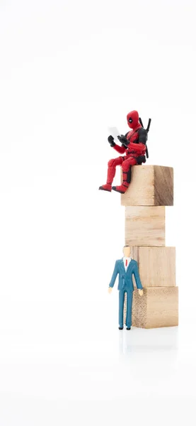 Kuala Lumpur, Malezya-5 Mart 2020: Deadpool veya Wade Winston Wilson 'ın Minyatür İnsanlar ve beyaz arka planda kelime bloğu olan aksiyon figürü.