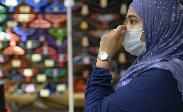 Coronavirus ve Hava kirliliği pm2.5 kavramı. Tıp maskeli genç ve güzel Müslüman kadın kameraya bakıyor. Wuhan koronavirüsü ve salgın virüs belirtileri..