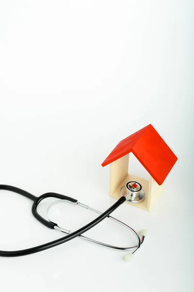 Concept of family medicine - Red Mini house and stethoscope isolated on white background