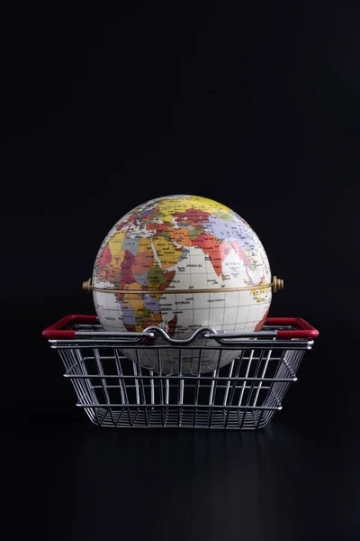 黑色背景下的小金属购物篮和全球模型 — 图库照片