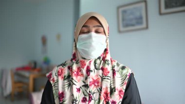 Coronavirus ve Hava kirliliği pm2.5 konsepti. Tıbbi maskeli genç, güzel Müslüman kadın, kameraya bakıyor. Sağlık ve tıbbi konsept.