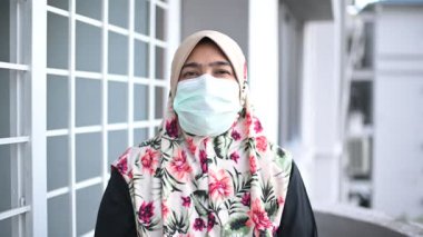 Coronavirus ve Hava kirliliği pm2.5 konsepti. Tıbbi maskeli genç, güzel Müslüman kadın, kameraya bakıyor. Sağlık ve tıbbi konsept.