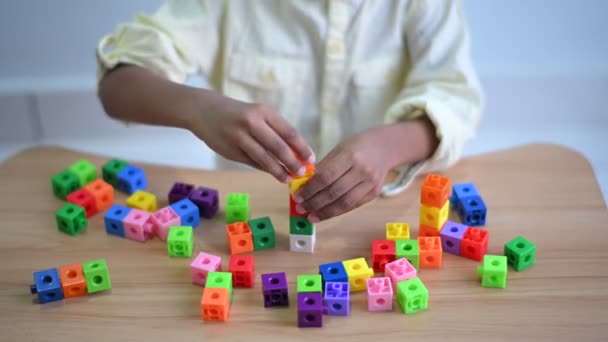 かわいいアジア人の手の閉鎖6歳の幼児男の子子供はリビングルームでプラスチックブロックと屋内で遊ぶのを楽しんでいます 若い子供のための教育用おもちゃの概念 — ストック動画