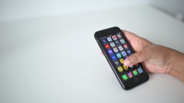 Kuala Lumpur, Malezya - 20 Nisan 2020: Ekranda akıllı telefonu ve MAYBANK 'ı olan genç kadın. Maybank akıllı telefonunuzdaki popüler ağı tarıyor. 4k çözünürlükte çekiliyor.