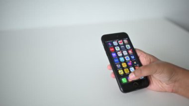 Kuala Lumpur, Malezya - 20 Nisan 2020: Sosyal medya. Adam iPhone akıllı telefonunda Instagram uygulaması kullanıyor. El kaydırmalı resimler, Instagram uygulamasındaki fotoğraflar bulanık arkaplanda, 4K 'da çekilmiş. 