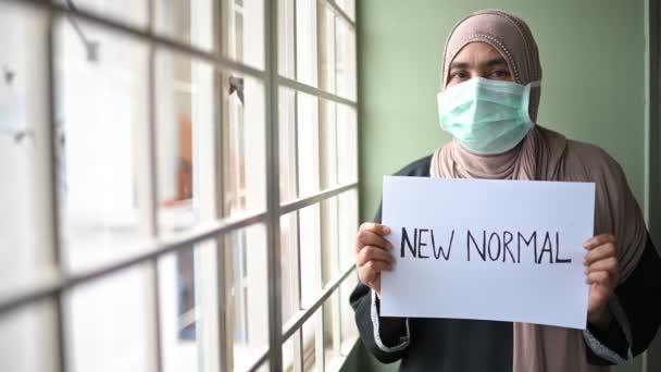 医療用マスクの若い美しいイスラム教徒の女性は カメラを見て 病気やほこりを防ぐために New Normal を描く示して 午後5時 自宅の検疫コロナウイルスパンデミック予防に滞在します スペースのコピー — ストック動画