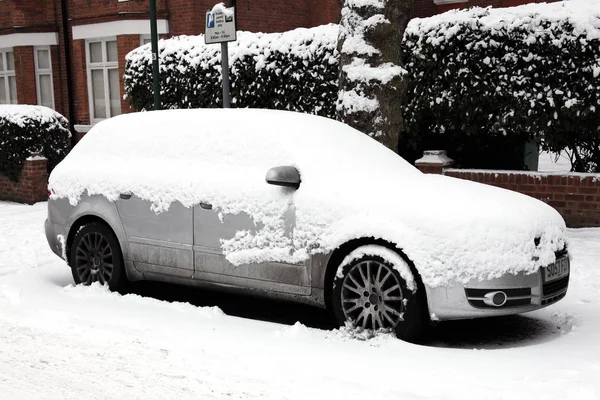 Una forte caduta di neve copre una macchina — Foto Stock