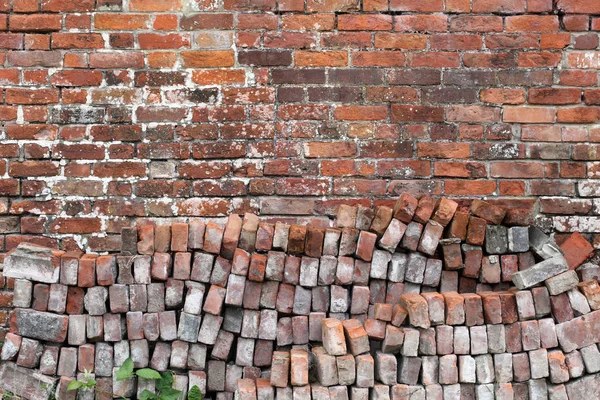 Vieux fond de mur de briques rouges avec pile de briques — Photo