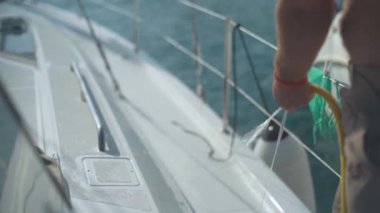 Adam yatı hortumla yıkar. Yavaş çekimde su ile.