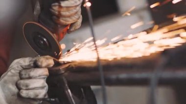 Adam sıcak metalden kıvılcım saçan dairesel testere sinekleri gibi çalışıyor.