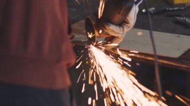 Adam sıcak metalden kıvılcım saçan dairesel testere sinekleri gibi çalışıyor.