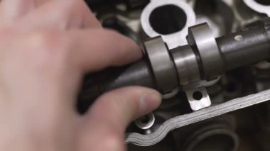 Tamirci bozuk motor başını tamir ediyor. Kam milini kapatıyor.
