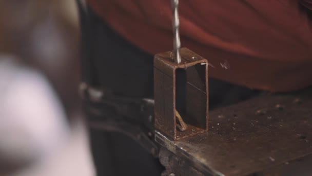Человек рабочий сверлит металл с электрической дрелью — стоковое видео