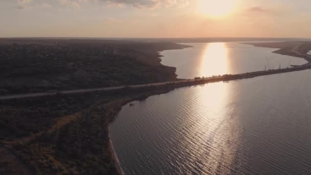 Aerial view of road passing by the sea cars drive over the bridge at sunset — Stock Video