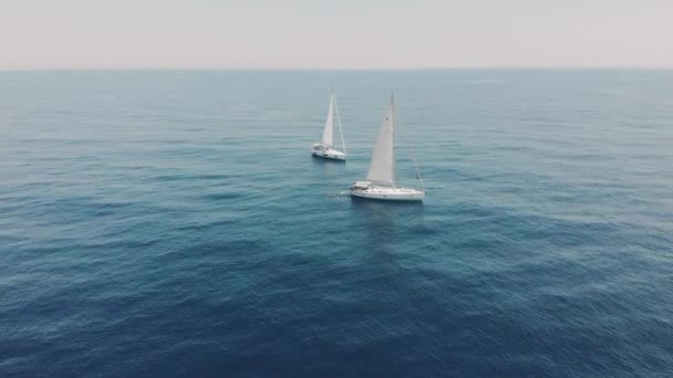 Aerial view of two yachts in the ocean silhouettes of swimming people — Stock Video