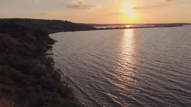 Vista aérea da estrada que passa pelos carros do mar dirigem sobre a ponte no por do sol — Vídeo de Stock