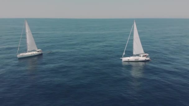 Aerial view of two yachts in the ocean silhouettes of swimming people — Stock Video