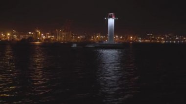 Gemi gece fenerin yanındaki limana gidiyor.