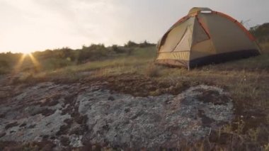 Kanyondaki kayalıklarda gün batımında çadır kampı