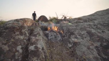 Gezgin adam dağlarda tavuk pişiriyor.