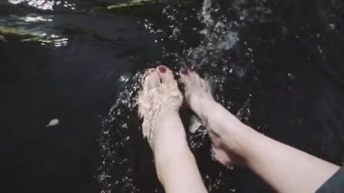 Nehir kenarında oturan bir kadın Kayanın kenarında