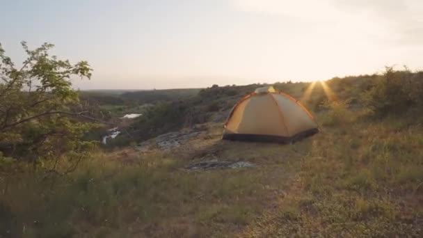 Tältläger under solnedgången på klipporna vid ravinen — Stockvideo