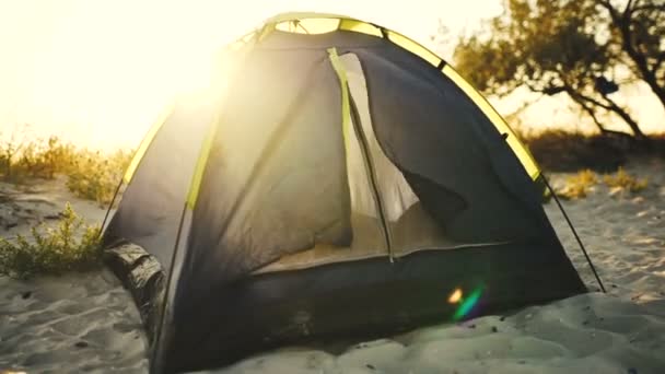 Acampamento tenda durante o pôr do sol na praia — Vídeo de Stock