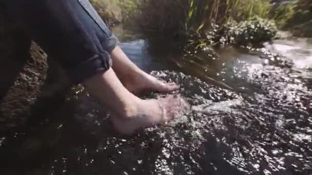 Frau sitzt am Fluss auf Felskante — Stockvideo