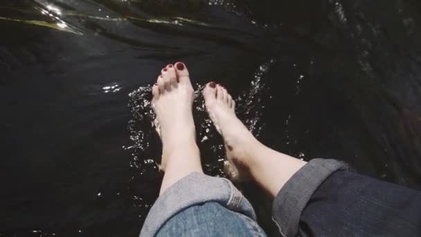 Nehir kenarında oturan bir kadın Kayanın kenarında — Stok video