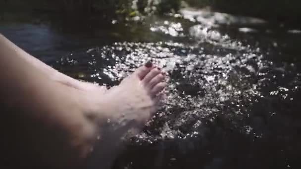 Woman sitting by river on edge of rock — Stock Video