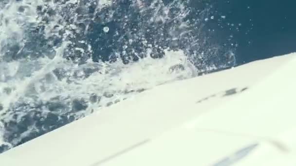 Yate rompe las olas de cámara lenta tiro de agua azul claro — Vídeos de Stock