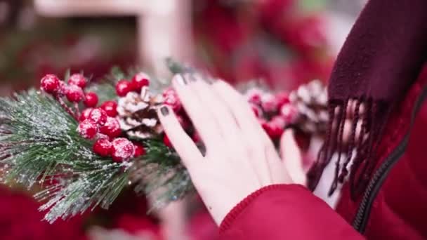Крупным планом женщина на рынке выбирает рождественские украшения — стоковое видео