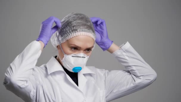 Mulher profissional médica está colocando meia máscara de filtragem com válvula de exalação em seu rosto, proteção — Vídeo de Stock