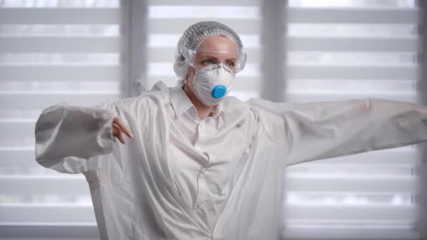 Salgın Covid-19. Bir kadın virüs enfeksiyonuna karşı koruyucu kıyafet giyer.. — Stok video