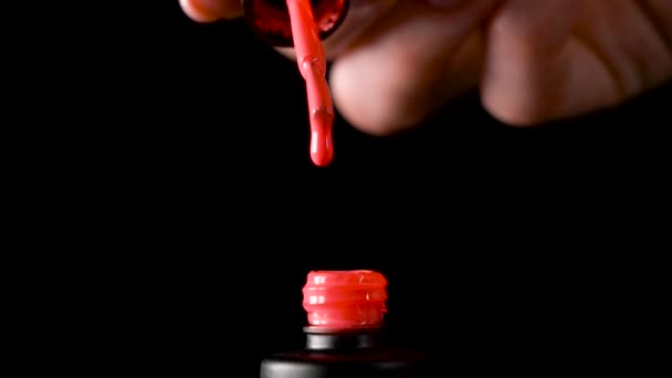 A drop of nail polish drips into an open bottle, Slow drop drops of nail gel varnish into the bubble — Stock Video