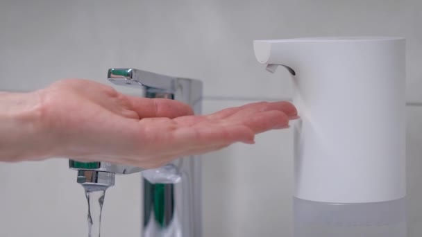 Автоматический генератор пены кладет на руку желаемую дозу мыла. Современная техника в ванной комнате — стоковое видео
