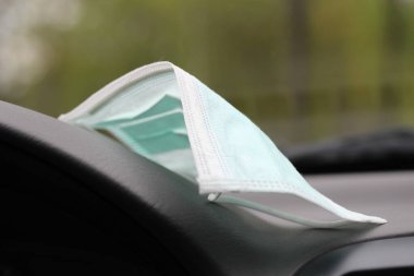Arabadaki gösterge panelinde tıbbi maske.
