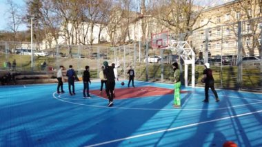 Lviv, Ukrayna - 22 Şubat 2020: Gençler halk meydanındaki şehir spor sahasında basketbol oynuyorlar.