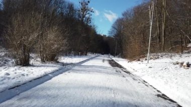 LVIV, UKRAINE - FEBRUARY 8, 2020: Winter park. Snow and sun. The guy runs down the road.