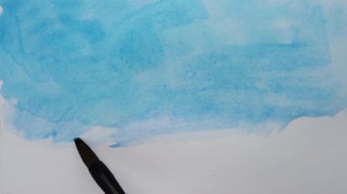 Kağıt üzerine suluboya resimler çizerek..