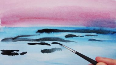 Kağıt üzerine suluboya resimler çizerek..