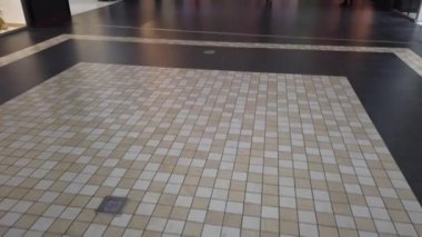 Alışveriş merkezinde zemin. Kiremit deseni. Alışveriş merkezindeki alıcılar.