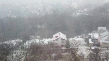 Pencerenin arkasındaki kar fırtınası şehrin arka planına karşı.