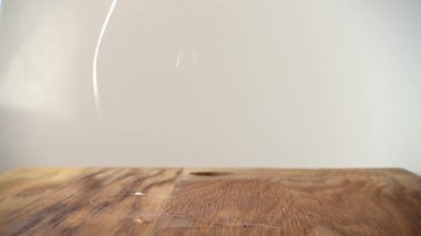 Aşçı kesme tahtasındaki yumurtayı kırar. Yavaş çekim.