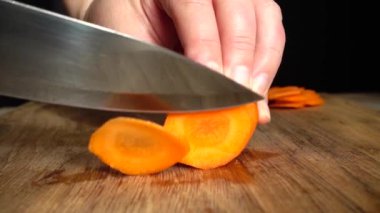 Aşçı bir bıçakla havuç keser. Yavaş çekim.