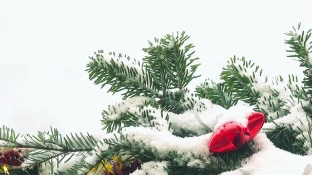 Takken Van Kerstboom Versierd Met Speelgoed Onder Sneeuw — Stockvideo