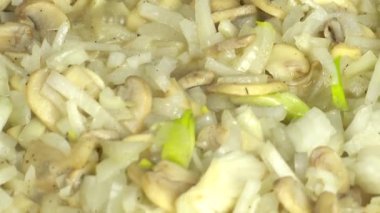 Şampiyonların soğanlı mantarlarının hazırlanması. Dökme demir tava.