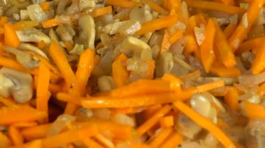 Şampiyon mantarlarının soğan ve havuçla hazırlanması. Dökme demir tava.