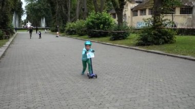 LVIV, UKRAINE - SEPTEMBER 21, 2019: Children 's cycling in the city park. Slow motion.